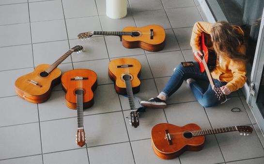Eine Schülerin beim Stimmen der Gitarren während des Musikworkshops in Lemgo. (vergrößerte Bildansicht wird geöffnet)